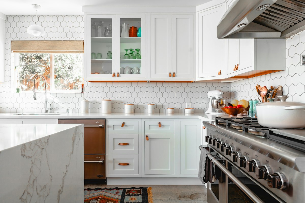 A professional cleaner wiping down a modern kitchen worktop